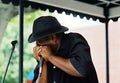 Blues artist playing a harmonica On Beale Street in Memphis, TN