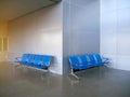 Blues waiting row chair on concrete polishing floor and grey aluminium composite wall back ground. Royalty Free Stock Photo