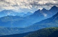 Bluish mist and dark clouds over forested ridges Dolomiti Italy Royalty Free Stock Photo