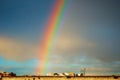 Blur abstract background. Rainbow over the roofs of residential buildings in cloudy weather after rain. Royalty Free Stock Photo