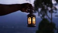 Blur background of hand holding a lantern in the dark. Person carry light of lantern in the night Royalty Free Stock Photo