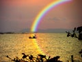 blur boat in sea sunset rainbow sky reflection rainbow on water Royalty Free Stock Photo