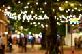 Blur - bokeh - Decorative outdoor string lights hanging on tree in the garden at night time Royalty Free Stock Photo