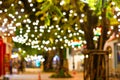 Blur - bokeh - Decorative outdoor string lights hanging on tree in the garden at night time Royalty Free Stock Photo