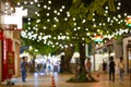 Blur - bokeh Decorative outdoor string lights hanging on tree in the garden at night time - decorative Christmas lights Royalty Free Stock Photo