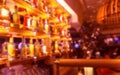 Blur a bottle of alcoholic drink on the shelves in club pub or bar against backdrop of dark party. Brightly lit bottles of Royalty Free Stock Photo