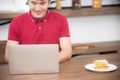 The blur business man with casual red t-shirt messaging on mobile phone, drinking coffee and eating sandwich, Young man working Royalty Free Stock Photo