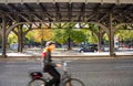 Blur cyclist wearing a helmet biking under a bridge in a street in Berlin, Germany