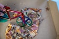 blur effect, woman hand cutting delicious pizza in carton box on table, bicycle pizza cutter knife on cheese in cardboard