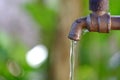 Water flowing from old steel faucet in outdoor space Royalty Free Stock Photo