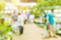 Blur Green plant tree and agriculture event in large exhibition center hall with people walking for shopping houseplant for