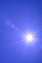 Blur image of a Beautiful morning Sun shines in blue sky.sunburst with Lens flare light over black background