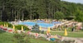 Blur image of people in public swimming pool in forest during summer season