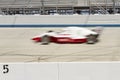 Blur of IRL car on track of motor speedway. Royalty Free Stock Photo