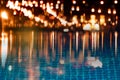 Blur light of bar or pub reflection on blue water swimming pool summer party at night background Royalty Free Stock Photo