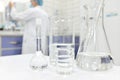 Blur male scientist working in a Chemistry Science laboratory with flask, beaker and glassware containing clear liquid chemical. Royalty Free Stock Photo