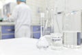 Blur male scientist working in a Chemistry Science laboratory with flask, beaker and glassware containing clear liquid chemical. Royalty Free Stock Photo