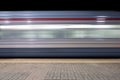 Blur motion of passenger train fast running beside railroad platform Royalty Free Stock Photo