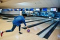 Blur photo of back south asian man throws bowling ball on motion at alley