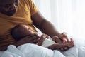 Blur soft images of An African American father holding  his 12-day-old baby newborn son lying in bed Royalty Free Stock Photo