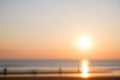 Blur sunset beach with bokeh abstract background. Blurred people in summer vacation concept. Beautiful sunrise orange sky and sun Royalty Free Stock Photo