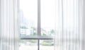 Blur of white curtain on window with city view background
