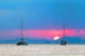 Blurred abstract background. Two sailing yachts in the sea. During sunset, the sun sets over the mountains Royalty Free Stock Photo