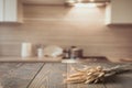 Blurred and abstract kitchen background. Wooden tabletop with wheat and defocused modern kitchen for display your products. Royalty Free Stock Photo