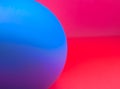 Blurred abstract photo with half blue sphere/ball on red/pink background