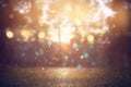 Blurred abstract photo of light burst among trees and glitter golden bokeh lights Royalty Free Stock Photo