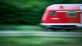 Blurred Abstract Photo of a Speeding Red Train with Foliage Background