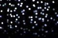 Blurred abstract white and blue sparkling lights background on black backdrop Royalty Free Stock Photo