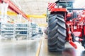 Blurred assembly workshop and tractor wheel at big industrial plant