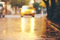 blurred autumn road with yellow leaves and car, rainy city street with streetlights, beautiful autumn nature