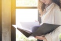 Blurred backgroud effect photo of Young businesswoman at workplace and reading paper in office. business woman wearing suit Royalty Free Stock Photo