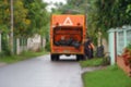 Blurred background back view garbage truck filled with garbage bag while service at street in the alley