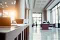 Blurred background of bright bank hallway with check desk, columns and shining warm sunlight