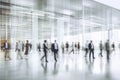 Blurred background of business people and activities inside an office building. The image captures the fast-paced and busy