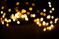 Blurred background. Christmas lights on a black background. Yellow light bulbs Royalty Free Stock Photo