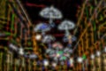 Blurred background of the city at night with bright glowing silhouettes of umbrellas