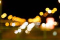 A blurred background of city road with glowing street lights.