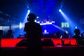 Blurred background : Club, disco DJ playing and mixing music for crowd of happy people. Nightlife, concert lights