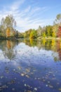 Blurred background with colorful autumn trees reflection on a calm lake under blue sky Royalty Free Stock Photo