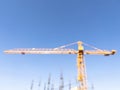 Blurred background with construction crane tower on blue sky. Crane and building working progress. Construction concept. Site. New Royalty Free Stock Photo