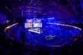 Blurred background of an esports event - Big illuminated main stage of a computer games tournament located on a big