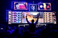 Blurred background of an esports event - Fan on a tribune at tournament`s arena with hands raised.