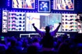 Blurred background of an esports event - Fan on a tribune at tournament`s arena with hands raised.