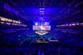 Blurred background of an esports event - Main stage venue, big screen and lights before the start of the tournament.