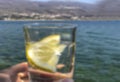 Blurred background with hand holding a glass water with lemon slice Royalty Free Stock Photo