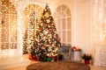 Blurred background illuminations Christmas interior with New Year tree and gifts in red, green colors Royalty Free Stock Photo